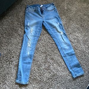 Light blue jeggings with rips in the front. The rips don’t show a ton of skin